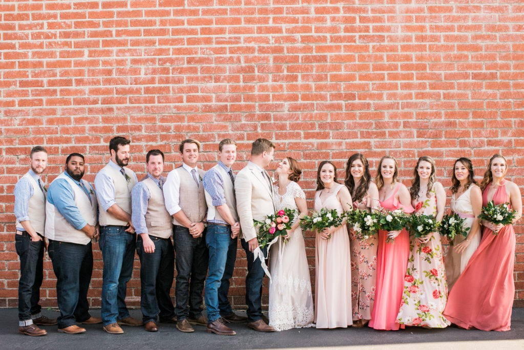 bridal party in front of brick wall 