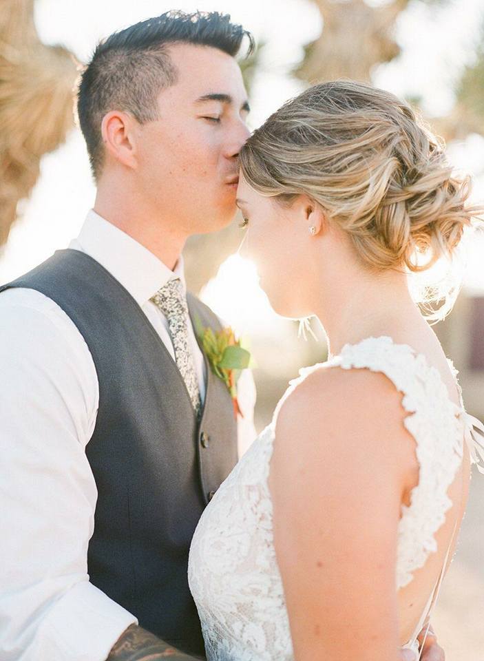 groom kisses bride in desert