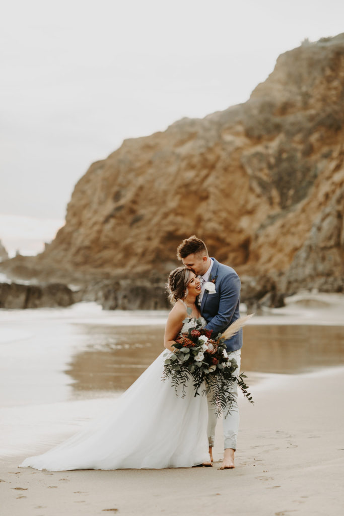 Bride and groom by the rocks in Laguna Beach after their intimate destination elopement