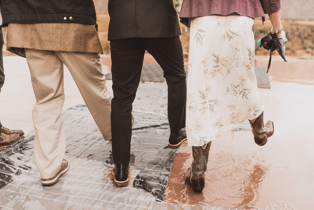 Groom walking through puddles on rugs as he walks down the aisle