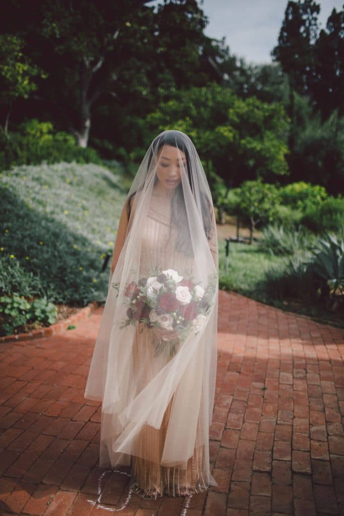 Romantic couple photos on their wedding day with a full length veil and champagne beaded wedding dress.