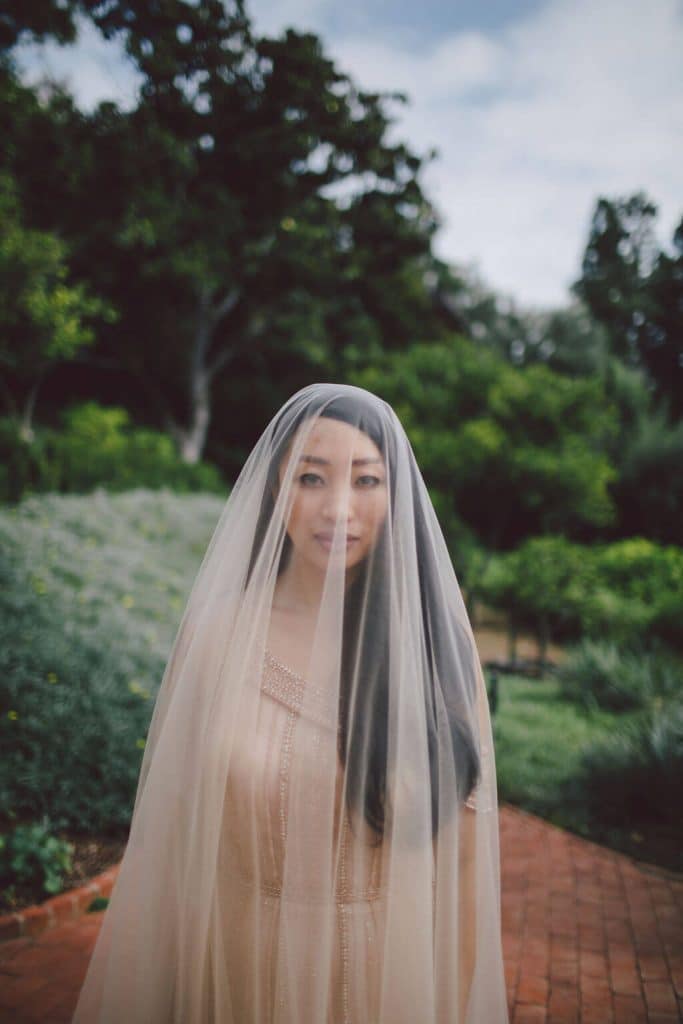 Beautiful bride with a full length veil on her wedding day complete with a champagne beaded wedding dress