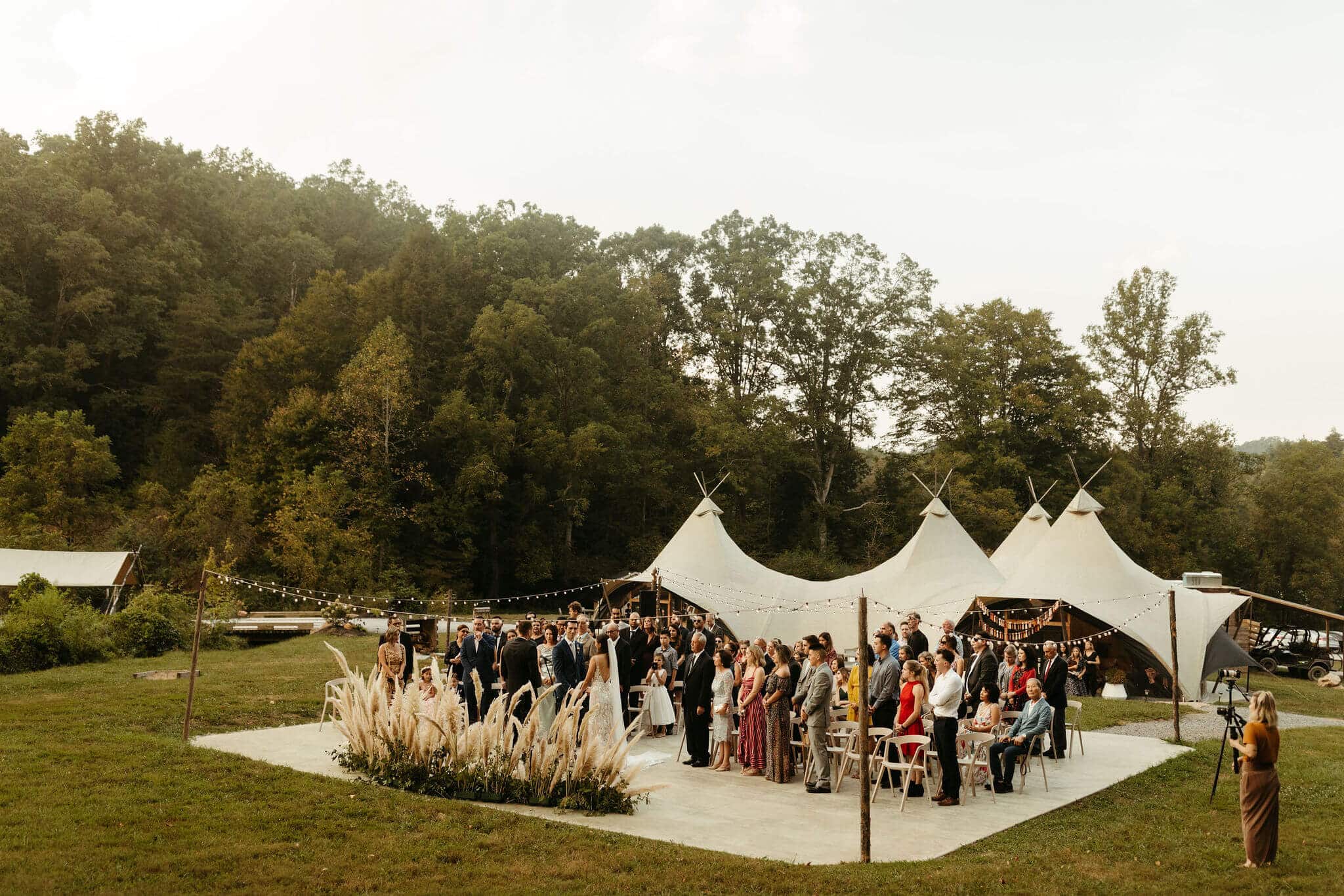 Ceremony set up with pampass grass and modern white chairs at Under Canvas Smoky Mountains. Festival style wedding in the great smoky mountains